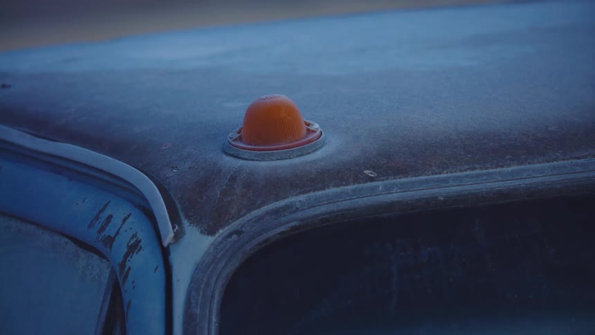 The top of an old pick up truck that's covered in rust and ice