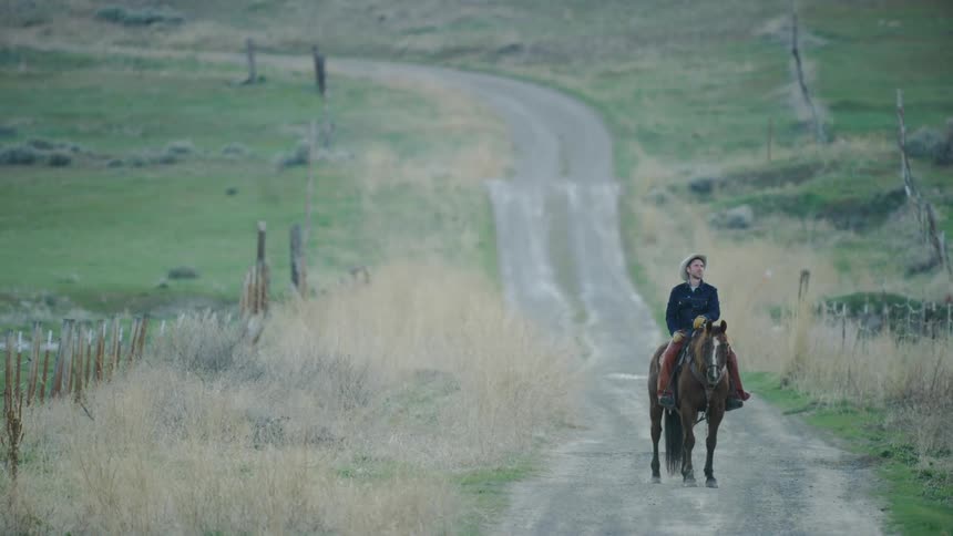 A middle age cowboy takes in the beauty of a long hard days work on a large Bison ranch deep in Montana