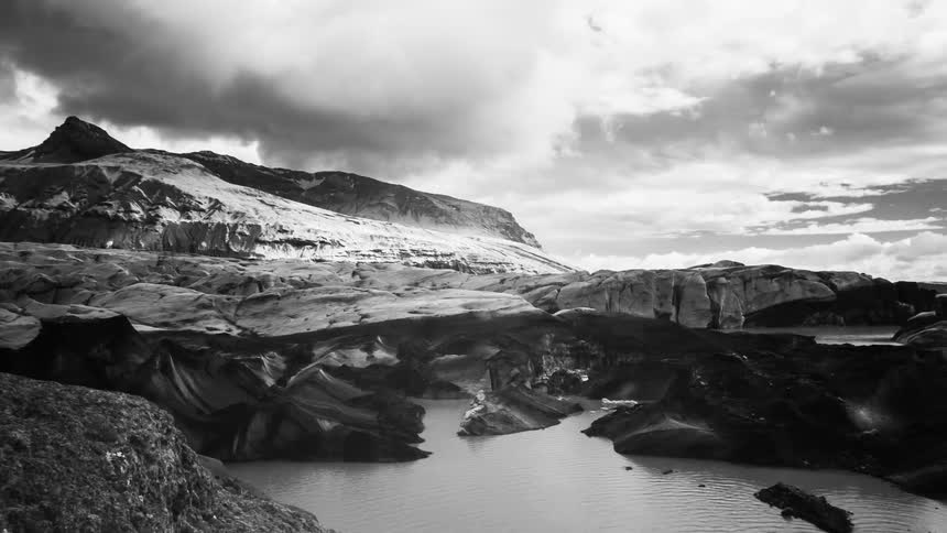 Black and white time lapse of clouds rolling over a lake in the mountains