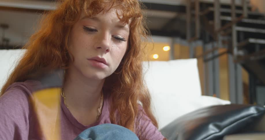 A teenage girl grabs a pen to take down notes