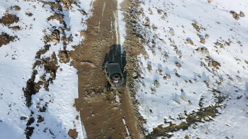 An off road vehicle drives on the dirt trail