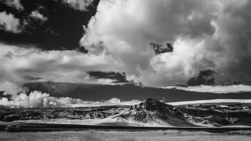 Black and white time lapse of clouds rolling over the mountains at daytime