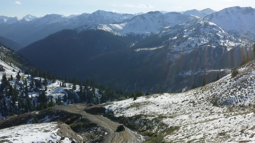 A vehicle travels down the small mountain road