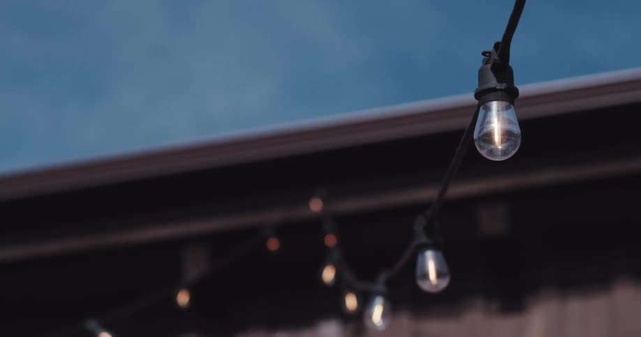 Light bulbs hanging from a cable outside a house