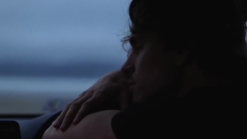 Man rests his head on his crossed arms