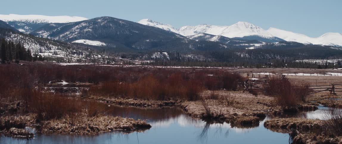 Lake in the countryside near the snow covered mountain range