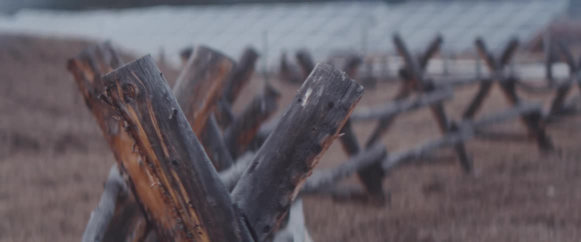 A wooden fence on a field with grass