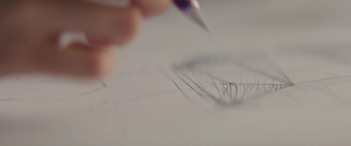 An artist drawing on a piece of white paper