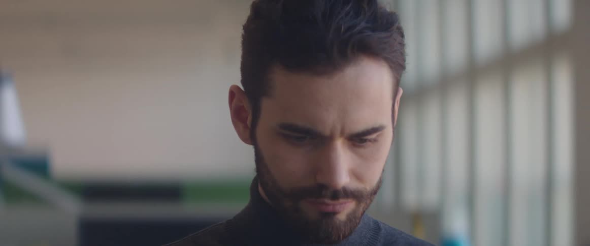 A man with facial hair deep in concentration indoors