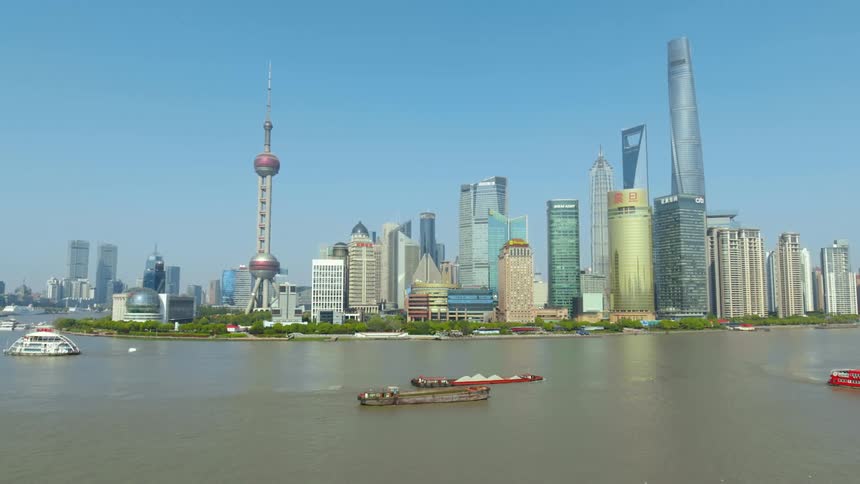 Multiple boats move along Shanghai Skyline slowly