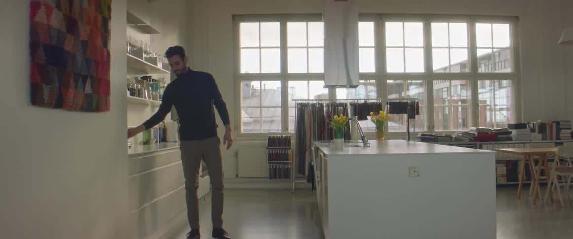 A man grabs the coffee pot and pours himself a cup of coffee standing in his home kitchen