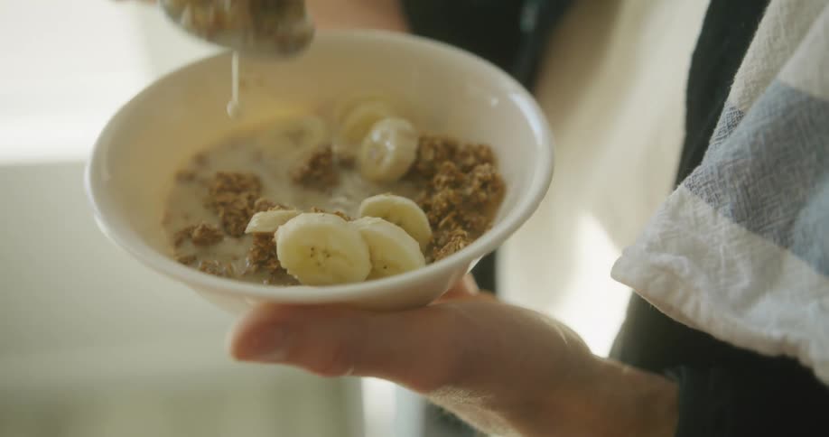A man eats a bowl of cereal