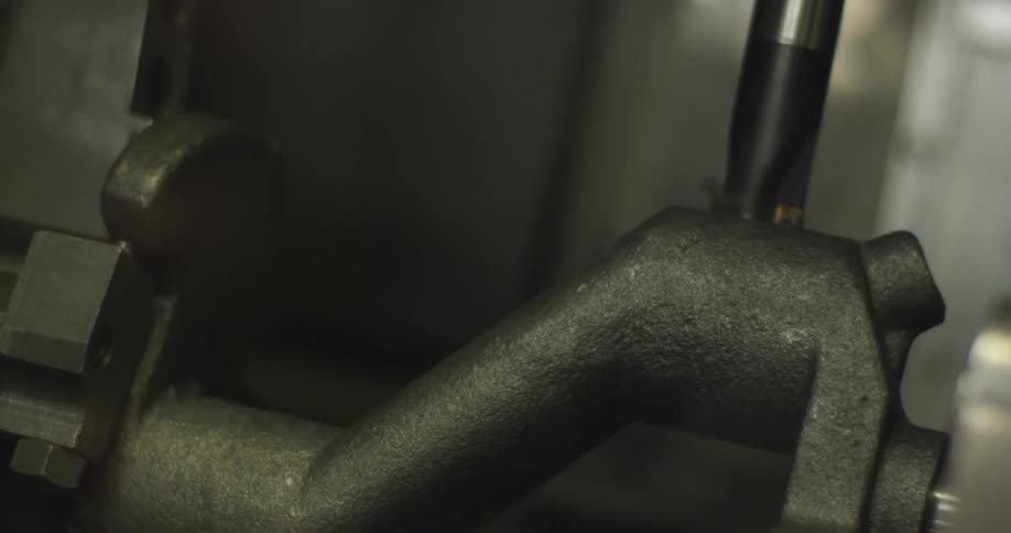 A tool drilling into a piece of metal in a workshop