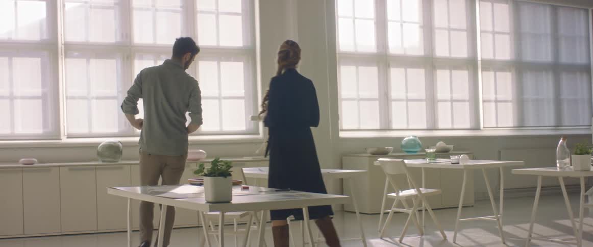 Coworkers walk into the office meeting room talking to each other