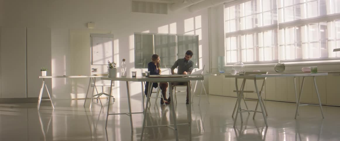 Coworkers walk into the office meeting room talking to each other