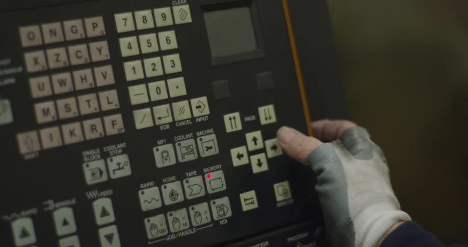A person with gloves touching buttons in a machine with a screen