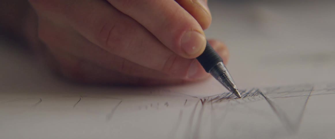 A person draws on a piece of paper
