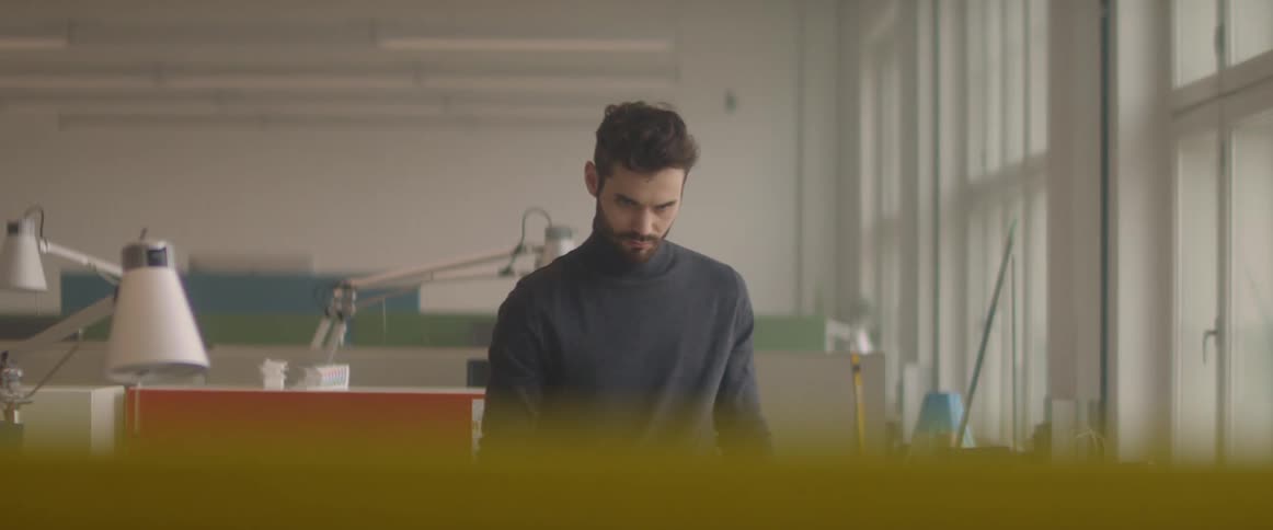Young bearded man wearing a long sleeve shirt working at the office
