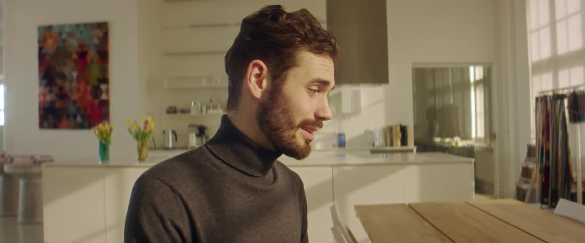 Young bearded man talking to coworkers on a video call in the office