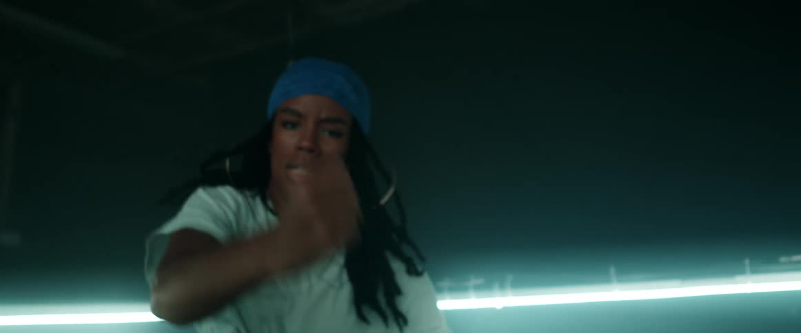 A woman is dancing outdoors at night