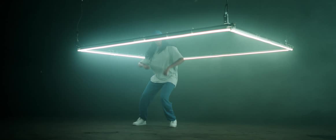 A woman with a bandanna dancing in a room with lights and smoke