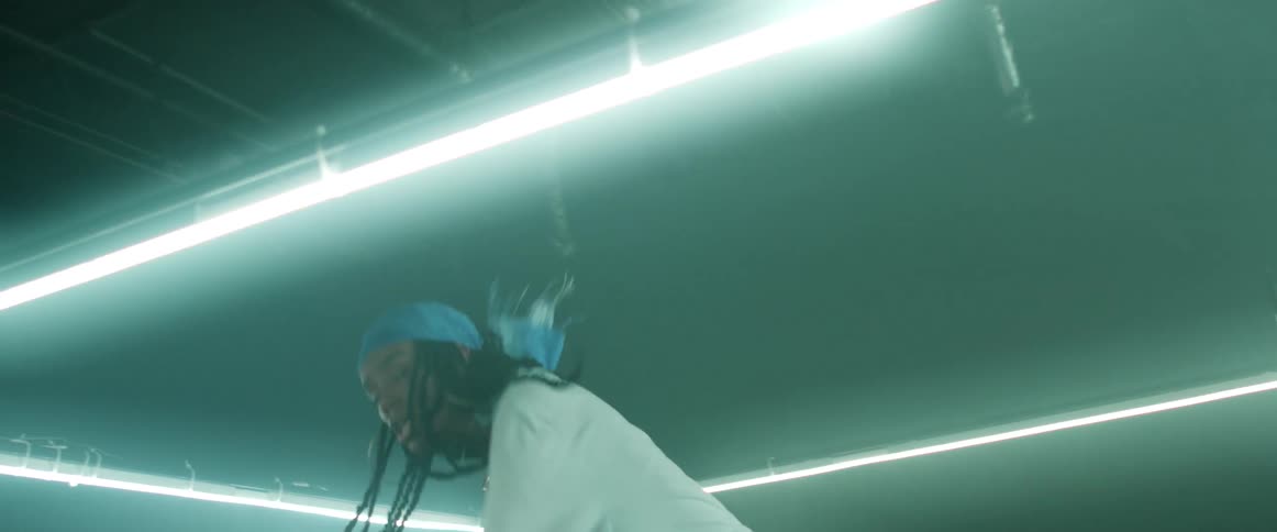 A woman with a bandanna and earrings dancing in a room