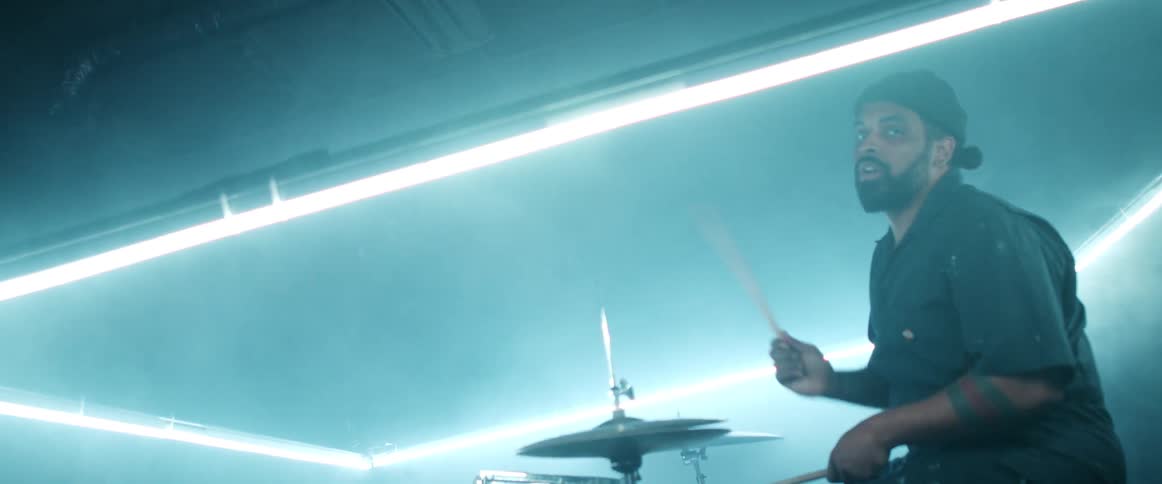 A man plays the drums on a stage