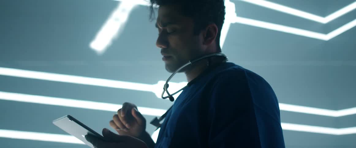 Man standing in front of a giant digital display using a tablet