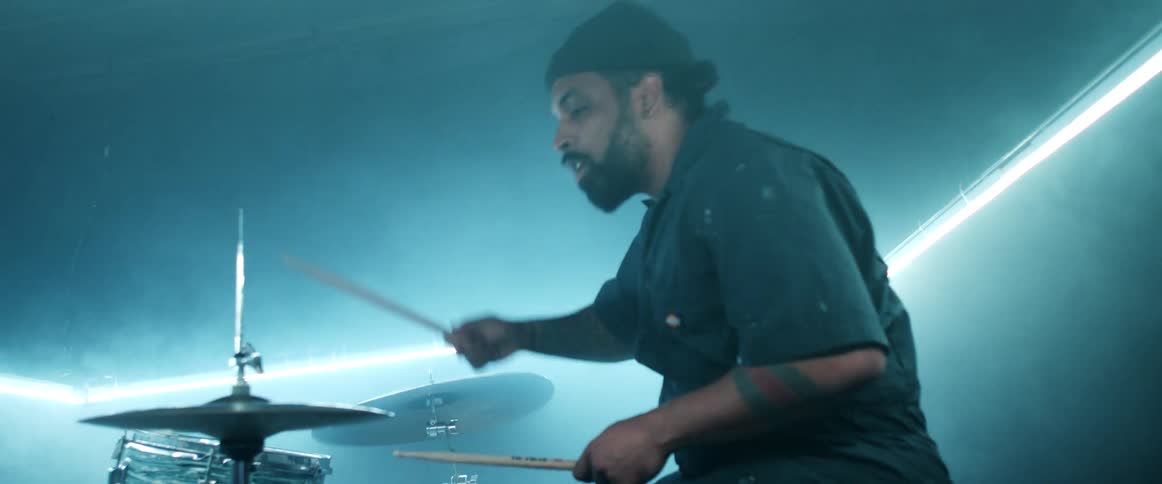 A man is performing on drums at a concert