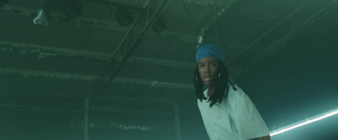 A female dance performs a hip hop style dance from within an array of bright lights