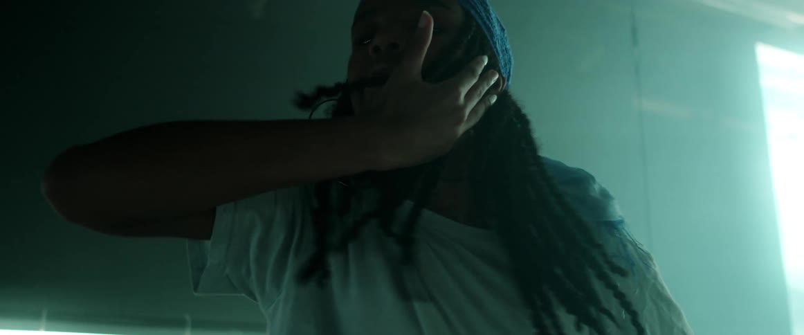 A woman with a bandanna and earrings dancing in a room