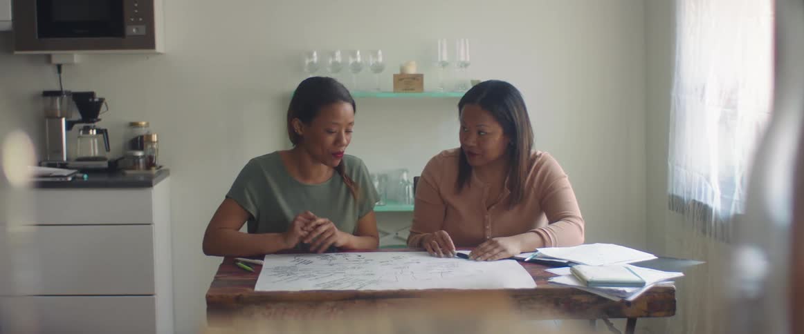 Two women talking while looking at a piece of paper