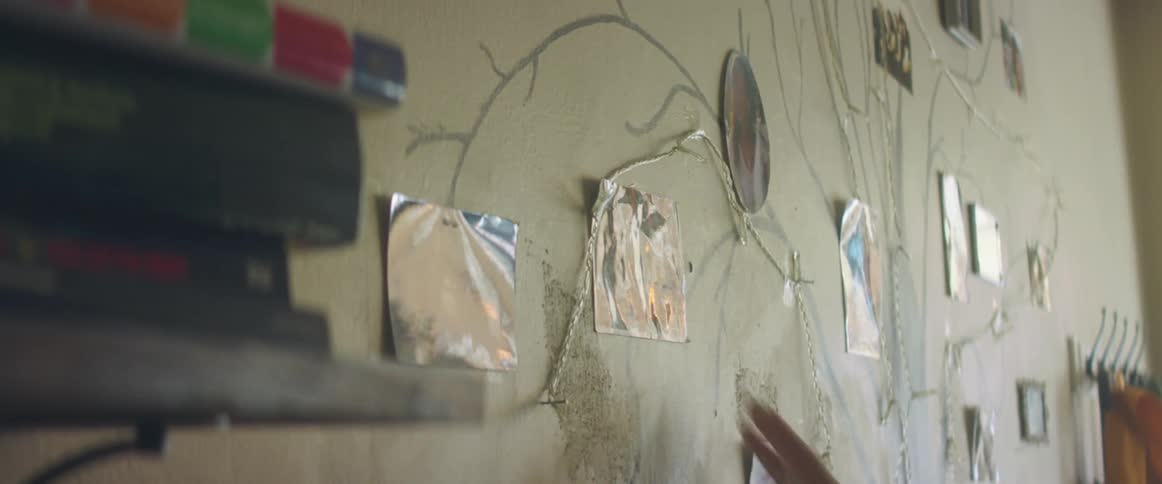 A person is putting pictures on the wall in a design