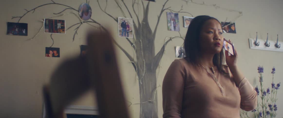 Sighing woman standing next to tree wall art dials phone