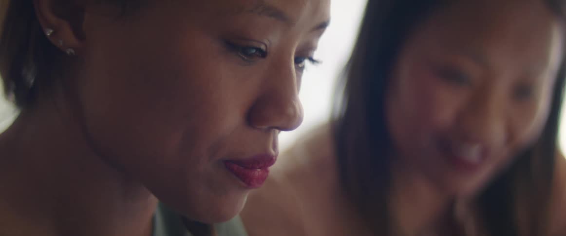 Two asian woman talk to each other and one nods in agreement with the other