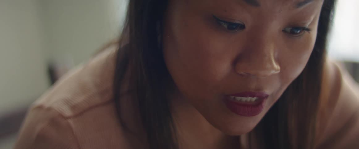 Close up of the face of a woman talking inside a room