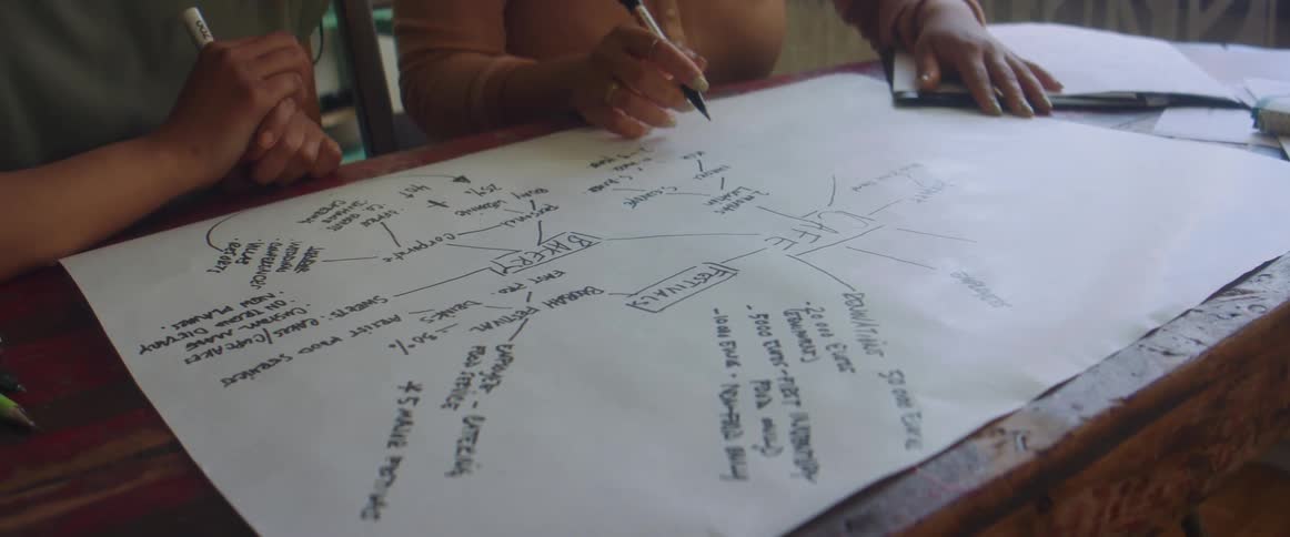 A person is writing information on a diagram