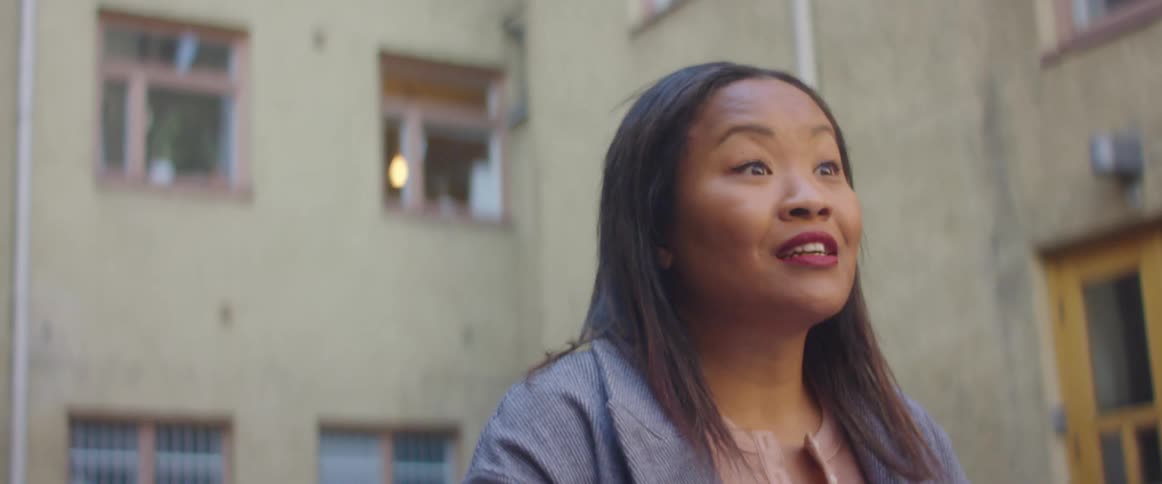 A woman stands outside a building and talks to someone