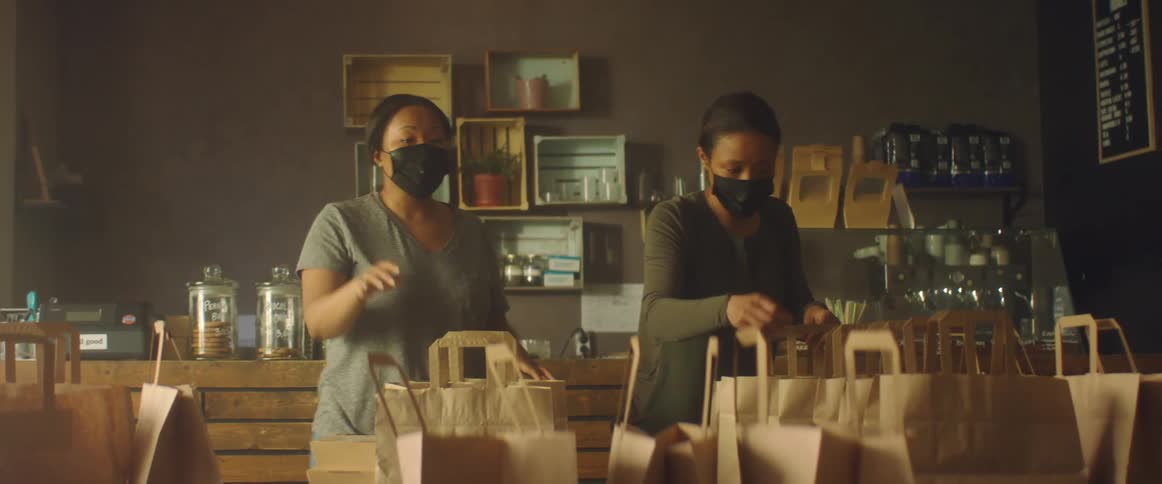 Two women pack takeout bags in the restaurant