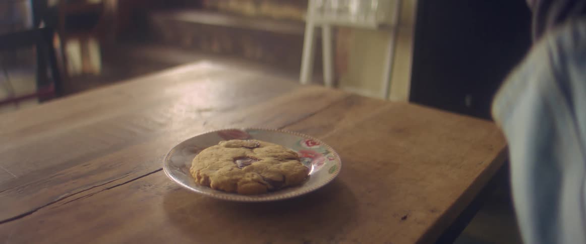 Woman reading a book is served a cookie and hot coffee at home