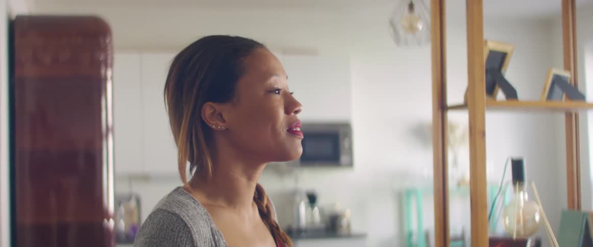 A woman is walking into a room and smiling