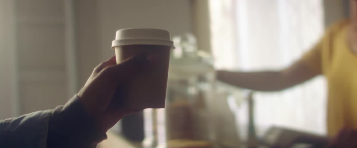 Person bought a plastic cup of coffee in the coffee shop