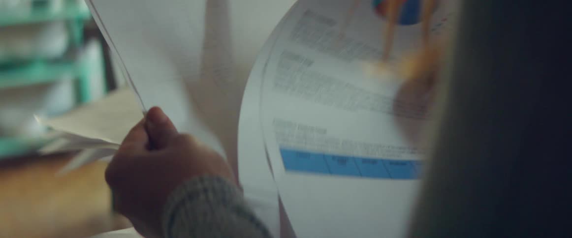 Woman with a grey sweatshirt reviews business plan papers