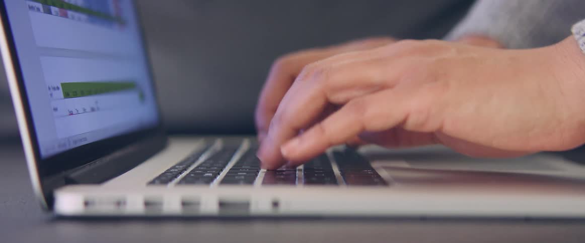 A person is typing on a laptop indoors
