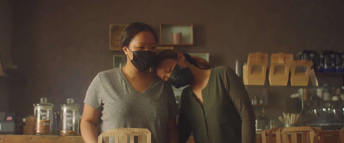 Women wearing black face masks working on a shop preparing an order