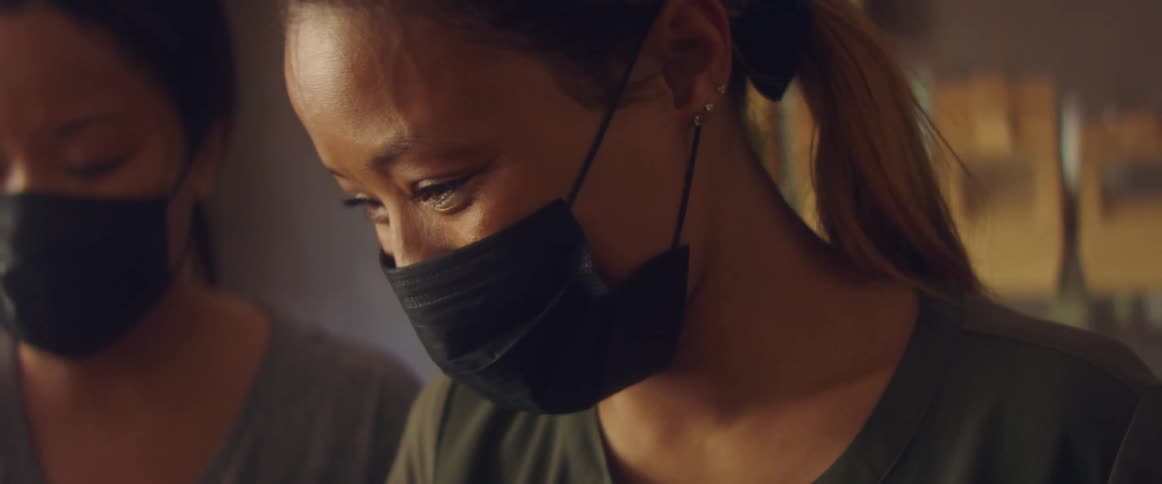 Two women are wearing face masks indoors