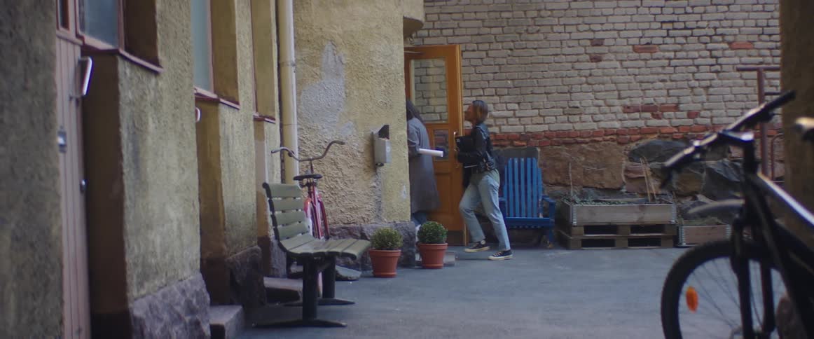 Two friends are talking and entering a building together
