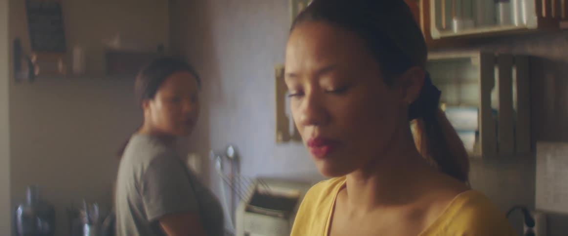 Two women listen to the radio attentively while bad news is being announced.