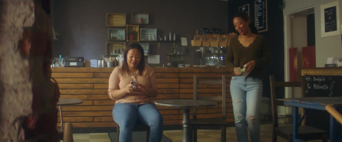 A woman walks to sit down next to a coworker