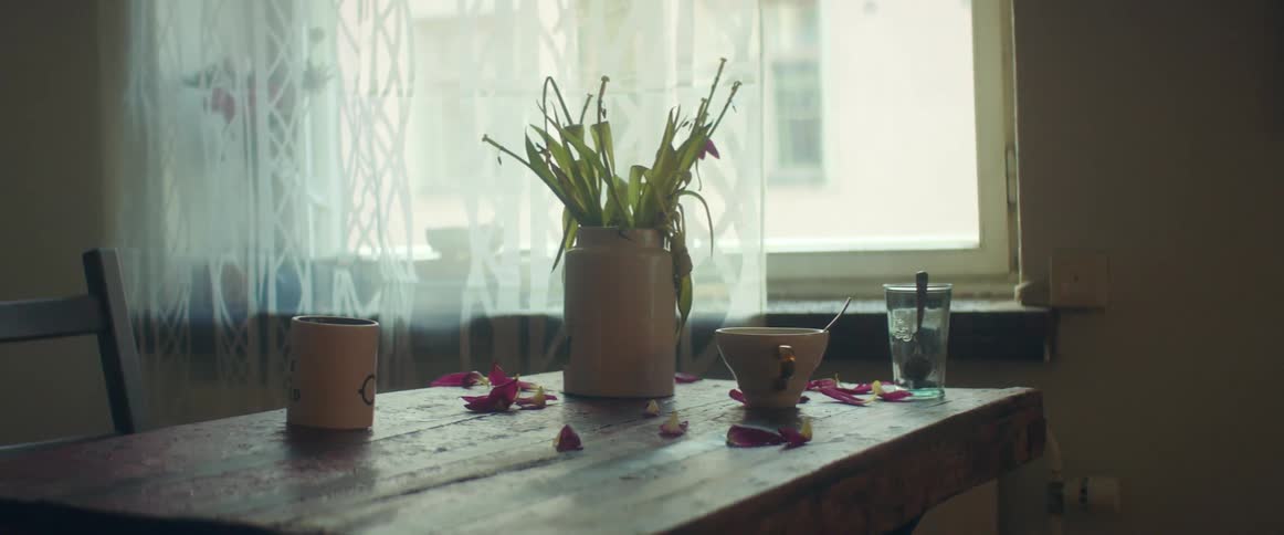 Dinner table with a bowl and a cup next to the windows